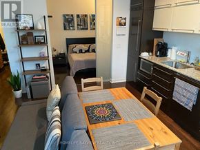 Toronto (Bay Street Corridor) condo for rent - A living room with a couch and a dining table.
