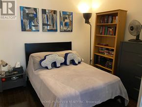 Toronto (Bay Street Corridor) condo for rent - A bedroom with a bed, nightstand, and bookshelf.