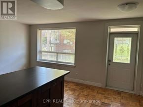 Toronto (Stonegate-Queensway) condo for rent - A room with a wooden floor and a door leading to a backyard.