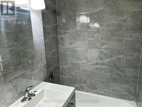 Toronto (Stonegate-Queensway) condo for rent - A bathroom with a marble tile wall and a white sink.