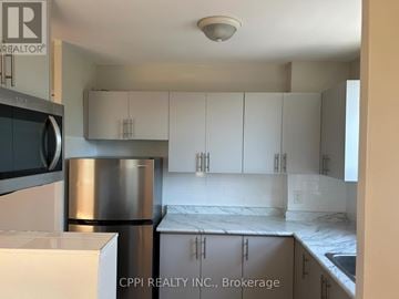Toronto (Stonegate-Queensway) condo for rent - A kitchen with white cabinets and a stainless steel refrigerator.
