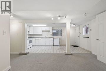 Vancouver apartment for rent - A spacious kitchen with white cabinets and appliances in a realtor listing photo.