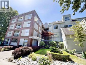 Vancouver apartment for rent - A red brick building with white trim and windows is surrounded by a well-manicured garden.