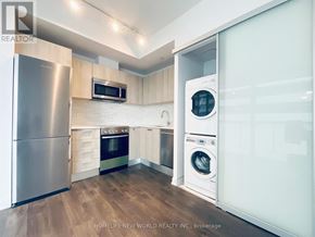Toronto (Church-Yonge Corridor) condo for rent - A modern kitchen with a refrigerator, microwave, oven, and washing machine.