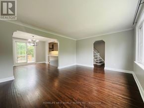 Toronto (Wexford-Maryvale) apartment for rent - A spacious room with wooden floors and a staircase in the background.