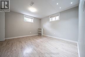 Oshawa (Central) duplex for rent - A room with wooden flooring and two windows.