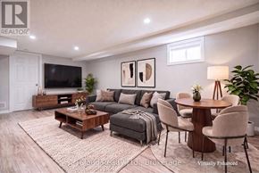 Oshawa (Central) duplex for rent - A living room with a grey couch, a wooden coffee table, and a flat screen TV.