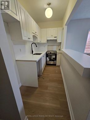 Toronto (University) apartment for rent - A kitchen with white cabinets and a wooden floor.