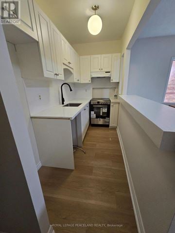 Toronto (University) apartment for rent - A kitchen with white cabinets and a wooden floor.