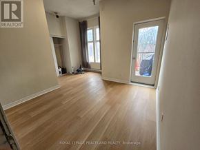 Toronto (University) apartment for rent - A room with wooden flooring and a sliding glass door.
