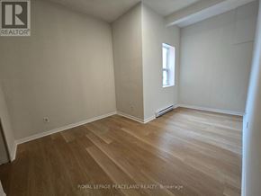 Toronto (University) apartment for rent - A room with wooden flooring and white walls.
