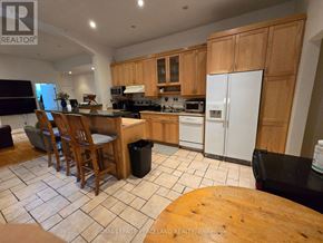 Toronto (Annex) multi-family for rent - A kitchen with wooden cabinets and a black fridge.
