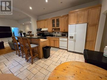Toronto (Annex) multi-family for rent - A kitchen with wooden cabinets and a black fridge.