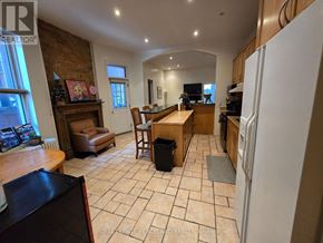 Toronto (Annex) multi-family for rent - A kitchen with a refrigerator, sink, and a dining table with chairs.