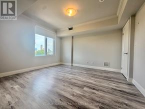 Niagara Falls (Hospital) condo for rent - A spacious room with wood flooring and a large window.
