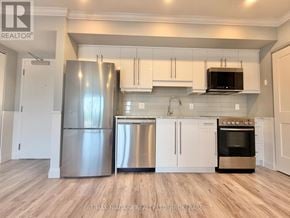 Niagara Falls (Hospital) condo for rent - A kitchen with stainless steel appliances and white cabinets.