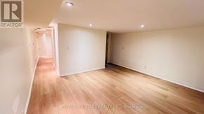 Toronto (Annex) townhouse for rent - A room with wooden flooring and white walls, with a logo that reads "RE/MAX All-Stars Realty Inc. Brokerage" in the bottom right corner.