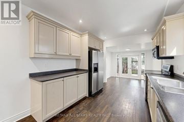 Toronto (Annex) townhouse for rent - A kitchen with wooden cabinets and a black countertop.