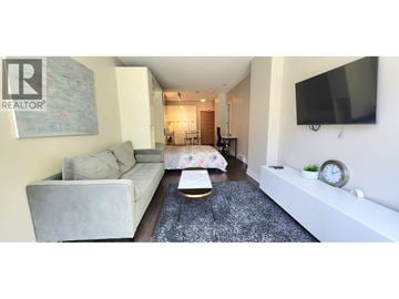 Vancouver apartment for rent - A living room with a grey couch and a coffee table in front of a TV.