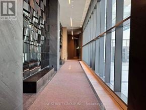 Vaughan (Vaughan Corporate Centre) condo for rent - A hallway with a marble wall and a bench.