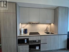 Vaughan (Vaughan Corporate Centre) condo for rent - A kitchen with a sink, stove, and cabinets.