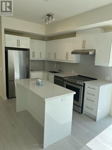 Vaughan (Vellore Village) condo for rent - A modern kitchen with white cabinets and a stainless steel refrigerator.