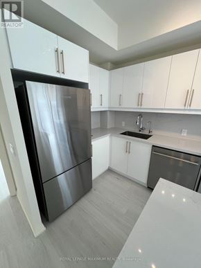 Vaughan (Vellore Village) condo for rent - A modern kitchen with a black refrigerator and white cabinets.