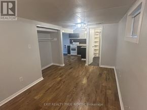 Barrie (Sanford) apartment for rent - A room with wood flooring and a kitchen area in the background.