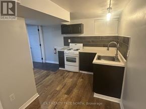 Barrie (Sanford) apartment for rent - A kitchen with a white stove top oven and a black counter top.