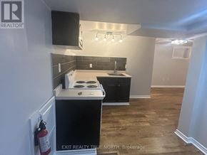 Barrie (Sanford) apartment for rent - A kitchen with a black countertop and a white stove top oven.
