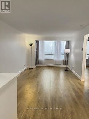 Mississauga (City Centre) condo for rent - A room with wooden flooring and a window with curtains.