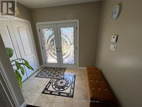 Brampton (Fletcher's Meadow) apartment for rent - A foyer with a bench, a door, and a clock on the wall.