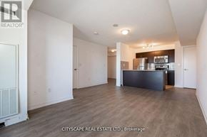 Toronto (Dovercourt-Wallace Emerson-Junction) condo for rent - A spacious living room with a kitchenette in the background.