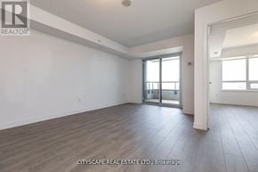 Toronto (Dovercourt-Wallace Emerson-Junction) condo for rent - A spacious room with wooden flooring and a sliding glass door.