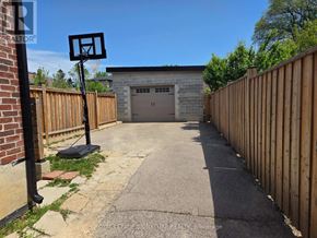 Toronto (Downsview-Roding-Cfb) apartment for rent - A basketball hoop stands in the middle of a driveway leading to a garage.