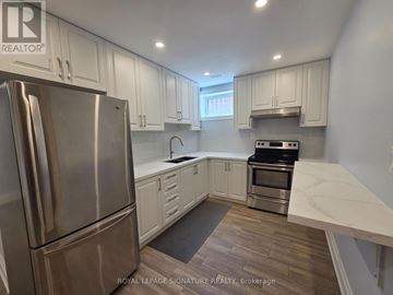 Toronto (Downsview-Roding-Cfb) apartment for rent - A kitchen with a stainless steel refrigerator and a stove top oven.