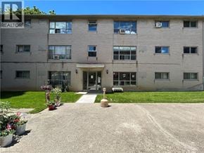 Dundas apartment for rent - A building with a lawn in front and a sign that says REALTOR.