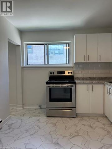 Dundas apartment for rent - A kitchen with a stove top oven and a window.