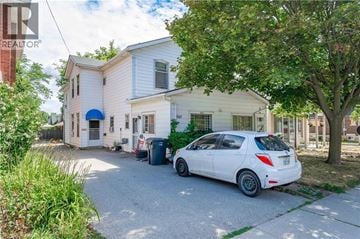 Guelph apartment for rent - A white car is parked in front of a two-story house.