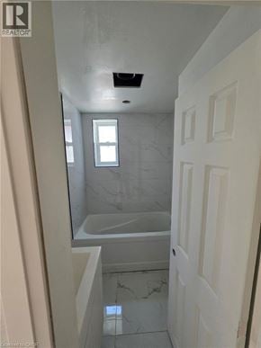 Guelph apartment for rent - A bathroom with a marble tub and shower.