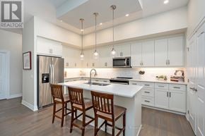 Guelph (Pineridge/Westminster Woods) condo for rent - A kitchen with white cabinets and a refrigerator.