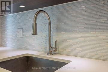 London East (East F) condo for rent - A modern kitchen with a sink and a wall of tiles.
