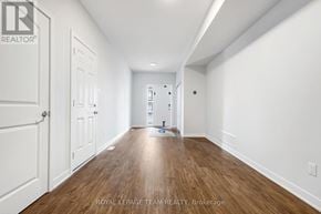 North Grenville townhouse for rent - A long, empty hallway with white walls and wood flooring.
