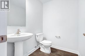 North Grenville townhouse for rent - A white bathroom with a toilet, sink, and mirror.
