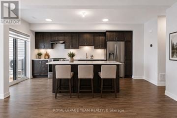 North Grenville townhouse for rent - A modern kitchen with dark wood cabinets and a center island.