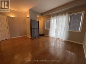 Ottawa townhouse for rent - A room with wooden flooring and a white curtain.