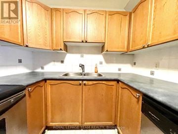 Ottawa townhouse for rent - A kitchen with wooden cabinets and a sink.
