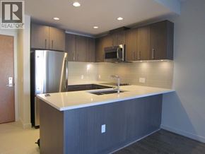 Vancouver apartment for rent - A kitchen with a refrigerator, microwave, and sink.