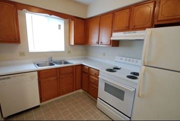 Gas City apartment for rent - A kitchen with white appliances and wooden cabinets.