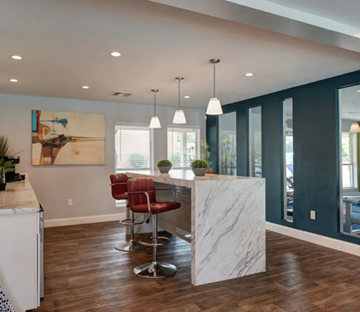 Houston apartment for rent - A modern kitchen with a marble island and red barstools.
